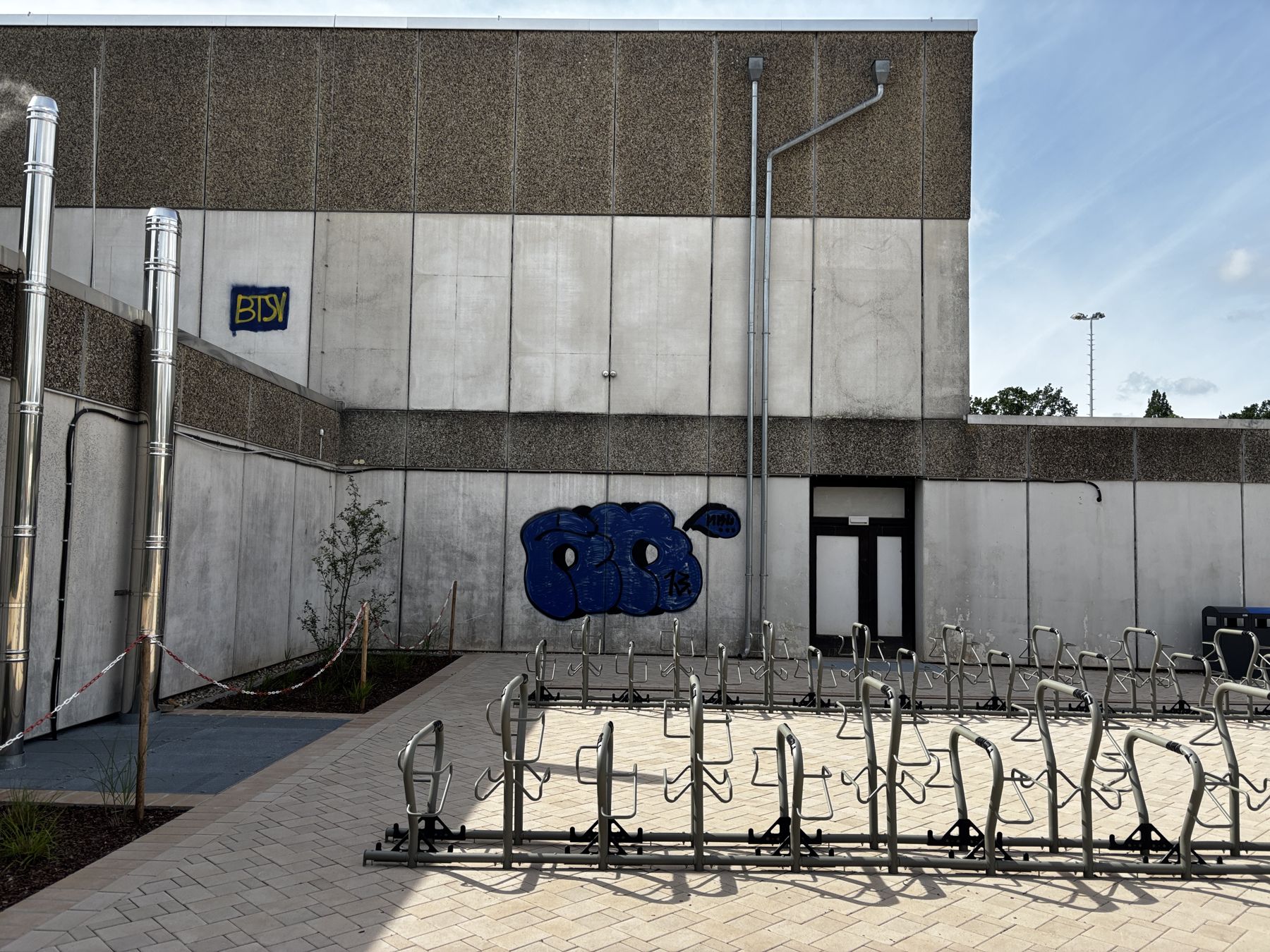 Betonfassade mit großem blauen Graffiti vor der Reinigung