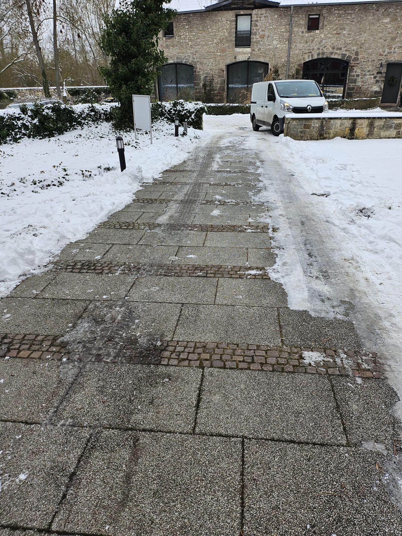 Geräumter Weg im Schnee vor einem Gebäude
